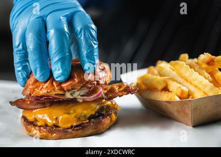 Cheeseburger mit Speck und Pommes frites. Stockfoto