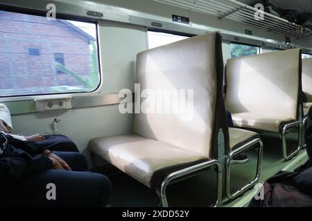 Lokale indonesische Bahnsitze der Economy Class mit offenen Fenstern am Morgen Stockfoto