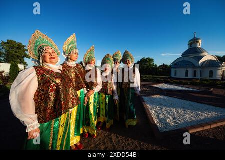 Frauen einer Tanzgruppe in traditionellen russischen Nationalwohnungen stehen vor dem Hintergrund der Orthodoxen Kirche des lebensspendenden Frühlings in St. Petersburg. Am 22. Juni feiert Russland den Tag des Gedenkens und der Trauer - dies ist der Tag des nationalen Gedenkens an die Opfer des Großen Vaterländischen Krieges. Am 22. Juni 1941, um 4 Uhr morgens, begann der Krieg zwischen der Sowjetunion und Deutschland. Am 21. Juni fand eine Gedenkveranstaltung „in der Nacht vom 22. Juni“ statt. Wurde in der Kirche der Heiligen Märtyrer Adrian und Natalia in Staro-Panovo abgehalten. Bei der Veranstaltung fand eine Gedenkfeier für alle Toten statt Stockfoto