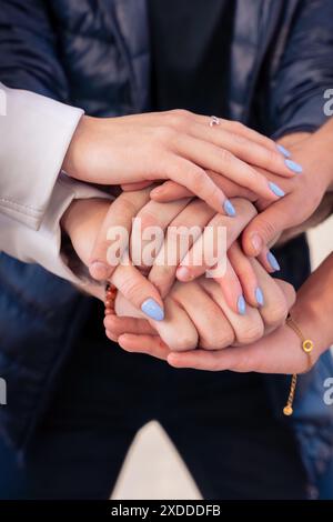 Nahaufnahme verschiedener junger Menschen, die draußen ihre Hände zusammenlegen. Stockfoto