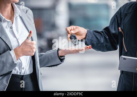 Nahaufnahme männliche Hand, die einen Autoschlüssel für die Finanzierung von Fahrzeugkrediten, Leasing- oder Mietkonzepten ausgibt Stockfoto