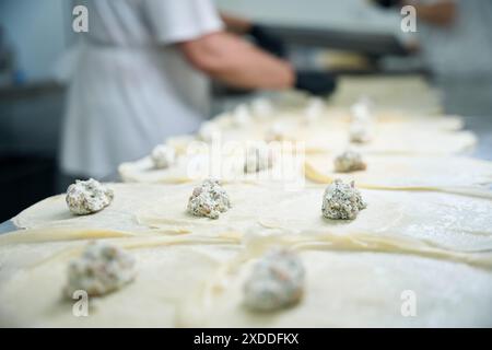 Weibchen legt Fischfüllung auf runde Pfannkuchen Stockfoto