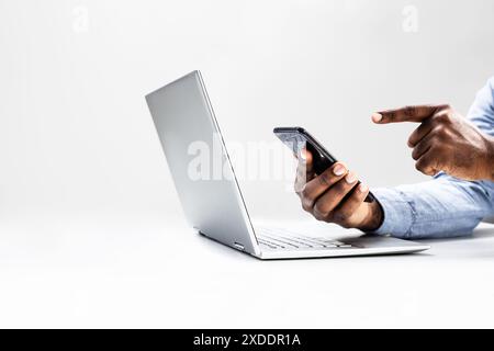 Fokussierter afroamerikanischer Mann nutzt Laptop für die Arbeit, verwaltet die Online-Präsenz für sein E-Commerce-Geschäft und verfolgt Finanztransaktionen. Stockfoto