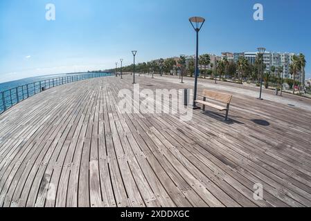 Holzpier Promenade entlang der Küste mit Palmen und Gebäuden in Limassol, Zypern Stockfoto