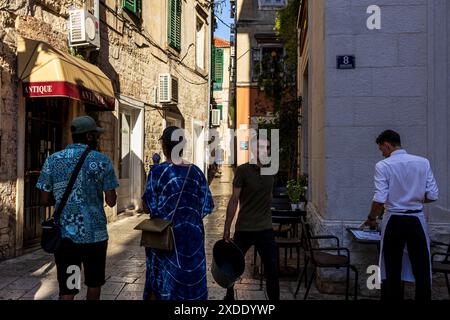 Split, Kroatien - 4. August 2023 : Menschen in einer engen Straße von Split Stockfoto