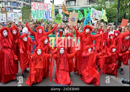 London, Großbritannien. Juni 2024. Restore Nature Now marschieren sie durch das Zentrum von London. Prominente wie Chris Packham, Megan McCubbin und Dame Emma Thomson führten den marsch von der Park Lane zum Parliament Square. Extinction Rebellion Red Brigade Credit: Phil Robinson/Alamy Live News Stockfoto