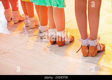 Mädchenfüße in Tanzschuhen stehen vor dem Turnier auf dem Boden. Nicht-olympischer Sport Stockfoto