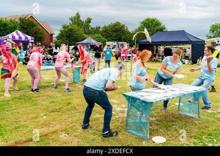 Zwei Teams von vier Personen in schicken Kleidern, die sich während der Custard Pie World Championships in Maidstone, Großbritannien, gegenseitig mit Puddingkuchen beworfen haben. Stockfoto