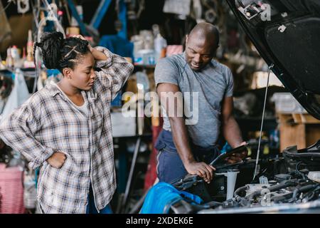 Mechaniker sprechen mit Stress Sorgen Kunden informieren Fahrzeugproblem erklären, Service Details harte Entscheidung in der Garage. Stockfoto