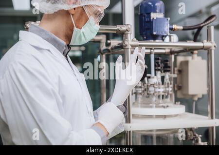 Wissenschaftler, die medizinische Latex-Handschuhe im Wissenschaftslabor tragen. Medizinisches Fabrikpersonal im Reinraum. Pharmazeutische Anlagen. Stockfoto