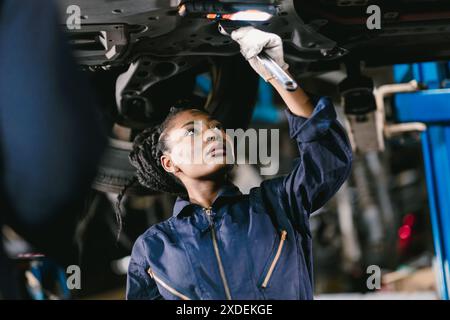 Mechaniker Afrikanische Frauen arbeiten Reparaturfahrzeug im Car Service. Professioneller Mitarbeiter: Fahrzeug in Werkstatt gemeinsam reparieren. Stockfoto