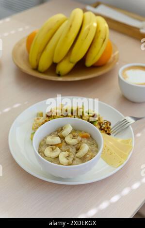 Haferbrei mit Banane in einer weißen Schüssel. Gesundes Frühstück. Blick von oben. Stockfoto