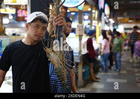 Bangkok, Thailand. Juni 2024. Ein Verkäufer zeigt Meeresfrüchte auf dem Thonburi Markt auf der Thonburi Seite von Bangkok, Thailand, 22. Juni 2024. Quelle: Sun Weitong/Xinhua/Alamy Live News Stockfoto