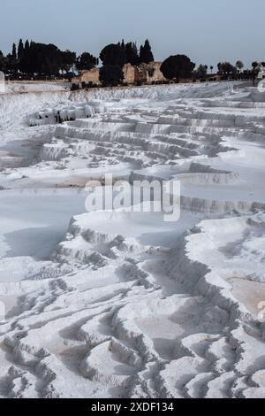 Ein wunderschöner, dramatischer Blick auf die berühmten weißen Travertinen von Pamukkale in Türkiye in der Nähe der alten Ruinenstadt Hierapolis, ein klassischer Touristenausflug. Stockfoto