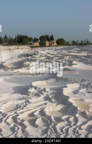 Ein wunderschöner, dramatischer Blick auf die berühmten weißen Travertinen von Pamukkale in Türkiye in der Nähe der alten Ruinenstadt Hierapolis, ein klassischer Touristenausflug. Stockfoto