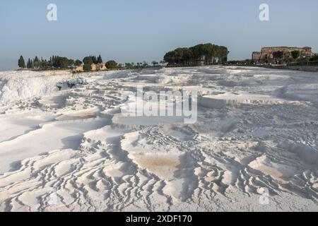 Ein wunderschöner, dramatischer Blick auf die berühmten weißen Travertinen von Pamukkale in Türkiye in der Nähe der alten Ruinenstadt Hierapolis, ein klassischer Touristenausflug. Stockfoto