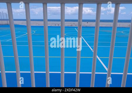 Teilweiser Blick von außen durch einige Bars eines Futsal-Feldes am Meer Stockfoto