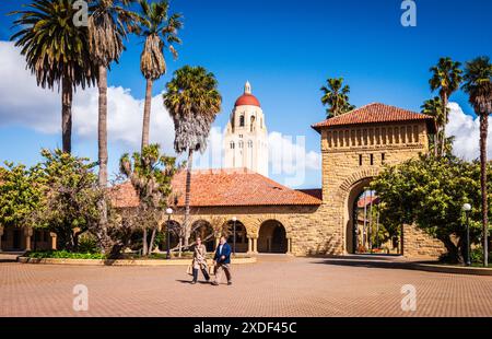 Stanford, Kalifornien, USA - 22. März 2017: Paar spazieren durch den Campus der Stanford University mit Hoover Tower im Hintergrund. Stockfoto