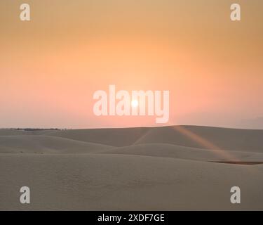 Sonnenaufgang über den atemberaubenden Zahek Dunes in Socotra, Jemen, wirft einen ruhigen Glanz über die weite Wüstenlandschaft Stockfoto