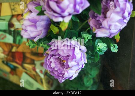 Im Garten gibt es einen wunderschönen Haufen lila Blumen umgeben von üppig grünen Blättern, die eine reizvolle und lebendige Darstellung schaffen Stockfoto