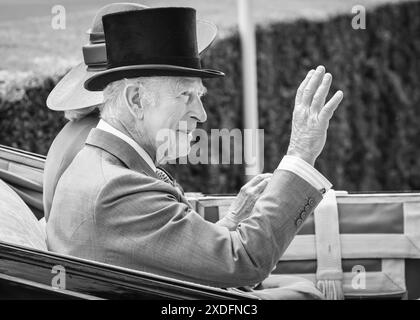König Karl III., in einem Tophut, lächelt und winkt von der Kutsche während der königlichen Prozession in Royal Ascot, England, Großbritannien Stockfoto