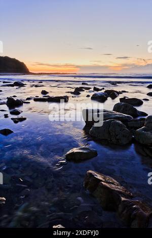 Dunkler Sonnenaufgang am Hams Beach an der australischen pazifikküste der Strandstadt Caves. Stockfoto