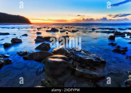 Malerische blaue Stunde Sonnenaufgang Sonnenaufgang am Hams Beach an der australischen pazifikküste in Caves Beach Town. Stockfoto