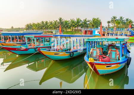 Hoi an (Hoian), Vietnam - 12. April 2018: Farbenfroher Blick auf traditionelle Holzboote, die sich im Wasser des Flusses Thu Bon spiegeln. Stockfoto