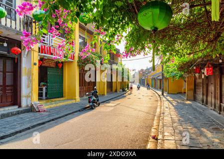 Hoi an (Hoian), Vietnam - 12. April 2018: Morgenblick auf die gemütliche Straße mit Blumen. Malerische traditionelle gelbe Häuser. Stockfoto