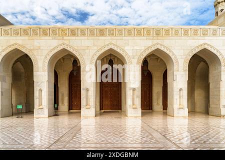 Muscat, Oman - 17. Oktober 2018: Wunderschöne Bogentore und geschnitzte Holztüren führen zur Sultan Qaboos Grand Moschee. Stockfoto