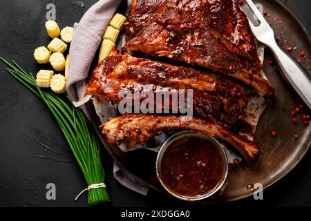 Heiße gegrillte Spare Ribs von einem Sommer BBQ serviert auf einem Teller mit Sauce. Draufsicht. Stockfoto