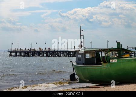 Fischerboot am Strand an einem sonnigen Morgen. Blick auf den Pier. Golf von Gdańsk, Gdynia Orłowo. Tourismus in Europa, Polen, Pommern, Gdynia. Relaxatio Stockfoto