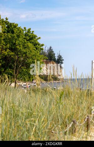 Blick auf die Klippe in Gdynia Orłowo an einem sonnigen Sommermorgen. Ruhige Ostsee. Große Felsbrocken im Vordergrund. Polen, Pommern, Gdynia. Stockfoto