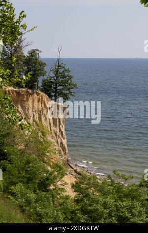 Blick auf die Klippe in Gdynia Orłowo an einem sonnigen Sommermorgen. Ruhige Ostsee. Große Felsbrocken im Vordergrund. Polen, Pommern, Gdynia. Stockfoto