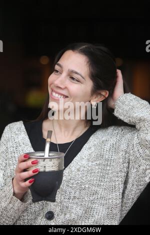 Porträt einer jungen, fröhlichen latino-Frau, die Yerba Mate trinkt Stockfoto