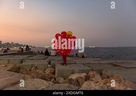 Alexandria, Ägypten. Dezember 2022. Ein junger Mann, der Ballons auf den Betonplatten von Alexandria Beach verkauft. Alexandria, die zweitgrößte Stadt in der nördlichen Delta-Region Ägyptens, ist aufgrund des steigenden Meeresspiegels vom Untergang bedroht. (Foto: John Wreford/SOPA Images/SIPA USA) Credit: SIPA USA/Alamy Live News Stockfoto