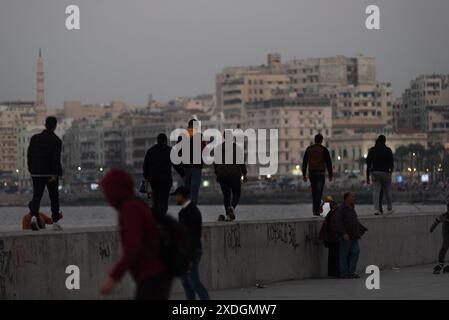 Alexandria, Ägypten. Dezember 2022. Lokale Jugendliche hängen auf dem betonplatz am Meer ab, Alexandria, Ägypten. Alexandria, die zweitgrößte Stadt in der nördlichen Delta-Region Ägyptens, ist aufgrund des steigenden Meeresspiegels vom Untergang bedroht. (Foto: John Wreford/SOPA Images/SIPA USA) Credit: SIPA USA/Alamy Live News Stockfoto