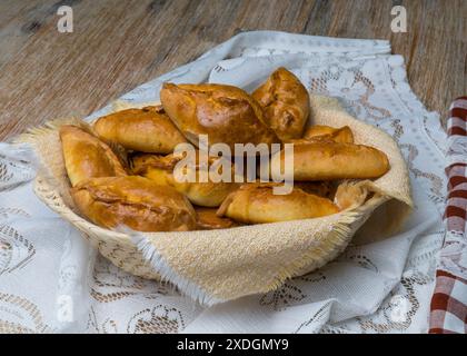 Kuchen mit Füllung in einen Korb auf einem Holztisch. Landmotiv. Stockfoto