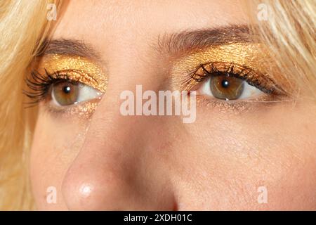 Frauenlook mit honigfarbenen Augen und blonden Haaren Stockfoto