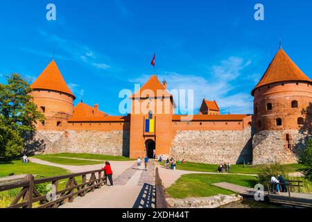 Vilnius, Litauen, 29. September 2023, wunderschöne rote Ziegelsteinruinen der trakai Burg auf der Insel, umgeben von grünem Gras, von vielen Touristen besucht Stockfoto