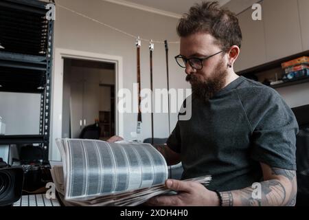 Fotograf, der Filmnegative im Studio untersucht Stockfoto