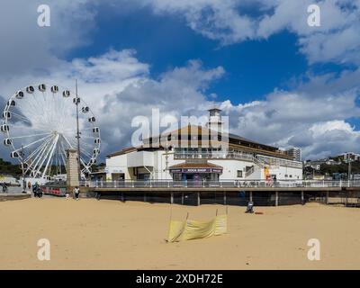 West Cliff Beach, Bournemouth, Großbritannien - 12. April 2024: Die Pier Arcade und das Aussichtsrad vom Strand aus gesehen. Stockfoto