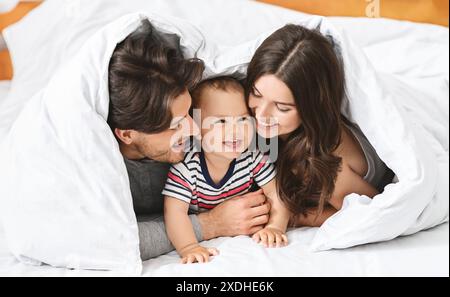 Happy Family Kuschelt Tagsüber Im Bett Zusammen Stockfoto