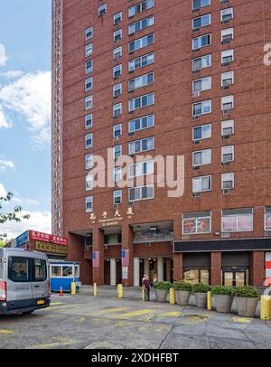 NYC Chinatown: Confucius Plaza, ein 44-stöckiger, sichelförmiger Wohnturm aus Backstein, mit einer Schule, einem Gemeindezentrum und Geschäften in der Basis. Stockfoto