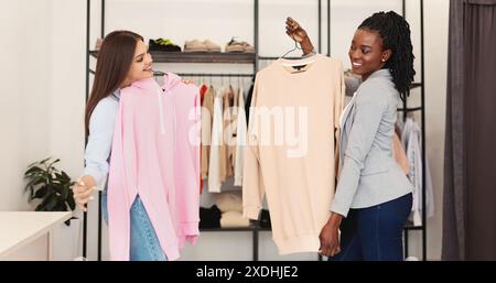 Zwei multirassische Frauen stehen nebeneinander im Modegeschäft Stockfoto