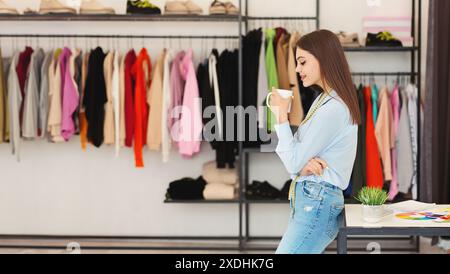 Junge Frau, die Modeentscheidungen in einer modernen Boutique erwägt Stockfoto