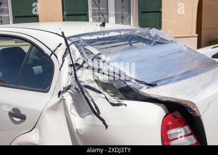 Die zertrümmerte Rückseite des Fahrzeugs mit Stretch- und Klebeband, das die Heckscheibe bedeckt. Gefährliche Straßenverkehrspraktiken Stockfoto