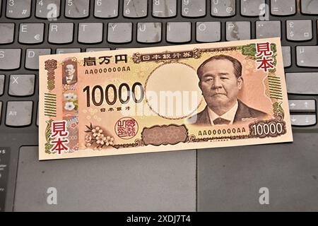 23. Juni 2024, Frankreich: In dieser Fotoabbildung wird ein Beispiel einer japanischen 10.000-Yen-Banknote auf die Tastatur eines Laptops gelegt. Um das Fälschungsrisiko zu verringern, werden das Finanzministerium und die Bank von Japan Anfang Juli 2024 neue Banknoten in Höhe von 1.000, 5.000 und 10.000 Yen in Umlauf bringen. (Credit Image: © Gerard Bottino/SOPA Images via ZUMA Press Wire) NUR REDAKTIONELLE VERWENDUNG! Nicht für kommerzielle ZWECKE! Stockfoto