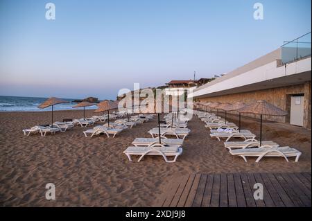 Leere Liegestühle am Strand am Abend bei Sonnenuntergang Stockfoto
