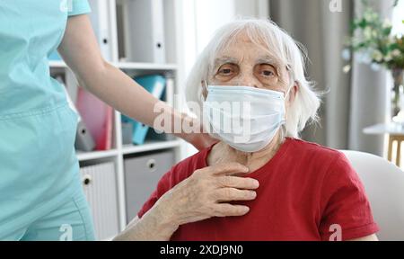 Ältere Frau Im Gesicht Schützende Medizinische Maske In Der Medizinischen Einrichtung Stockfoto